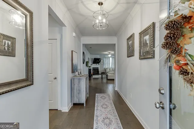 a view of a hallway view with living room and wooden floor