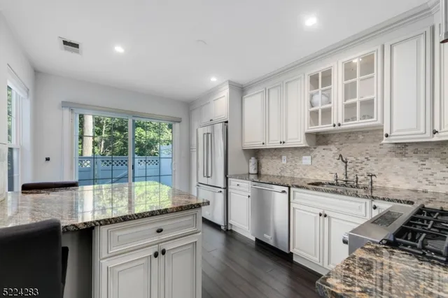 a kitchen with granite countertop a sink stove and cabinets