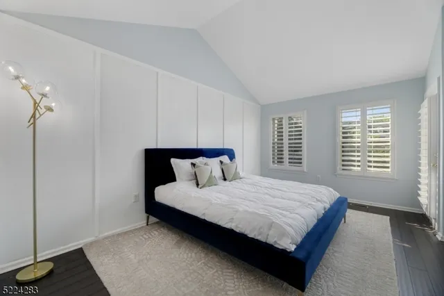 a bedroom with a bed lamp and a window