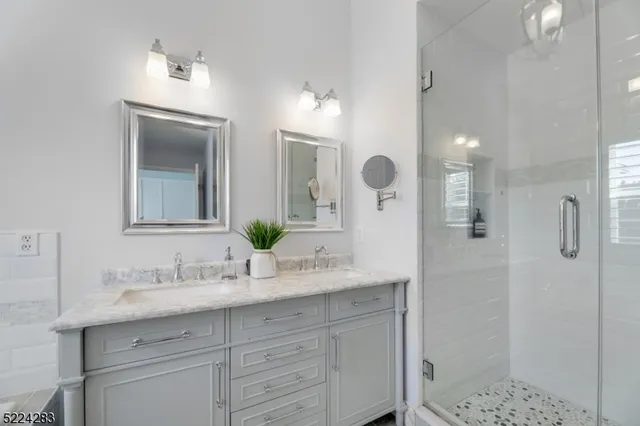 a bathroom with a double vanity sink mirror and shower