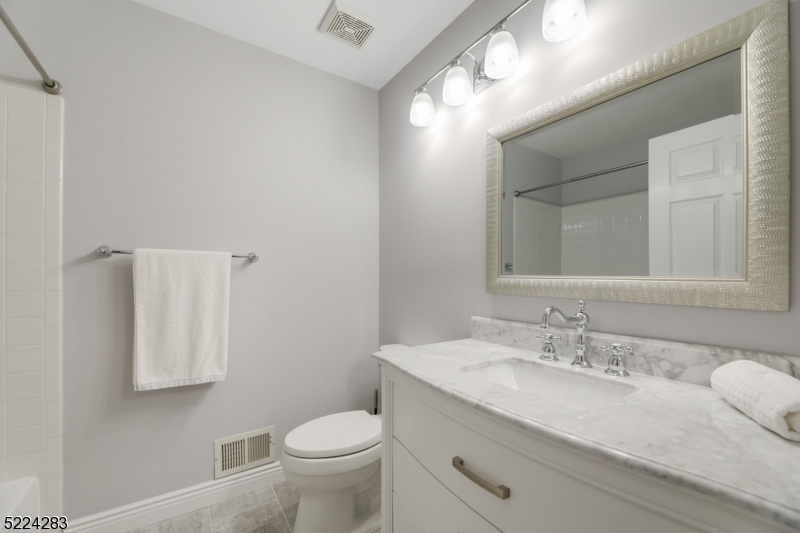 13 Knox Court Bernards, NJ 07920 - Photo 10 of 16 a bathroom with a granite countertop sink a toilet and a mirror