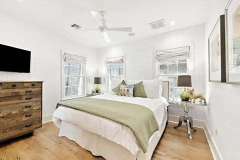 a bedroom with a bed and a flat tv screen on dresser