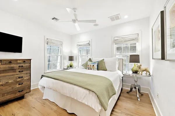 a bedroom with a bed and a flat tv screen on dresser
