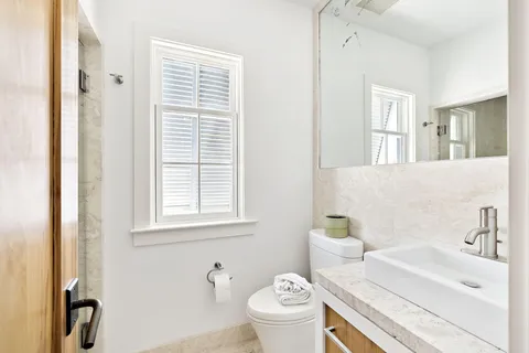 a bathroom with a sink a toilet and a window