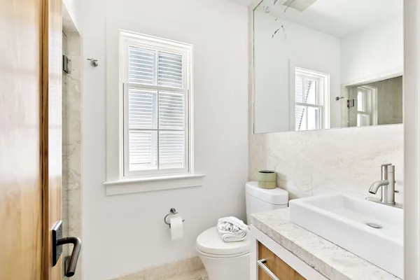 a bathroom with a sink a toilet and a window