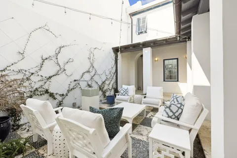 a view of a patio with couches table and chairs and potted plants