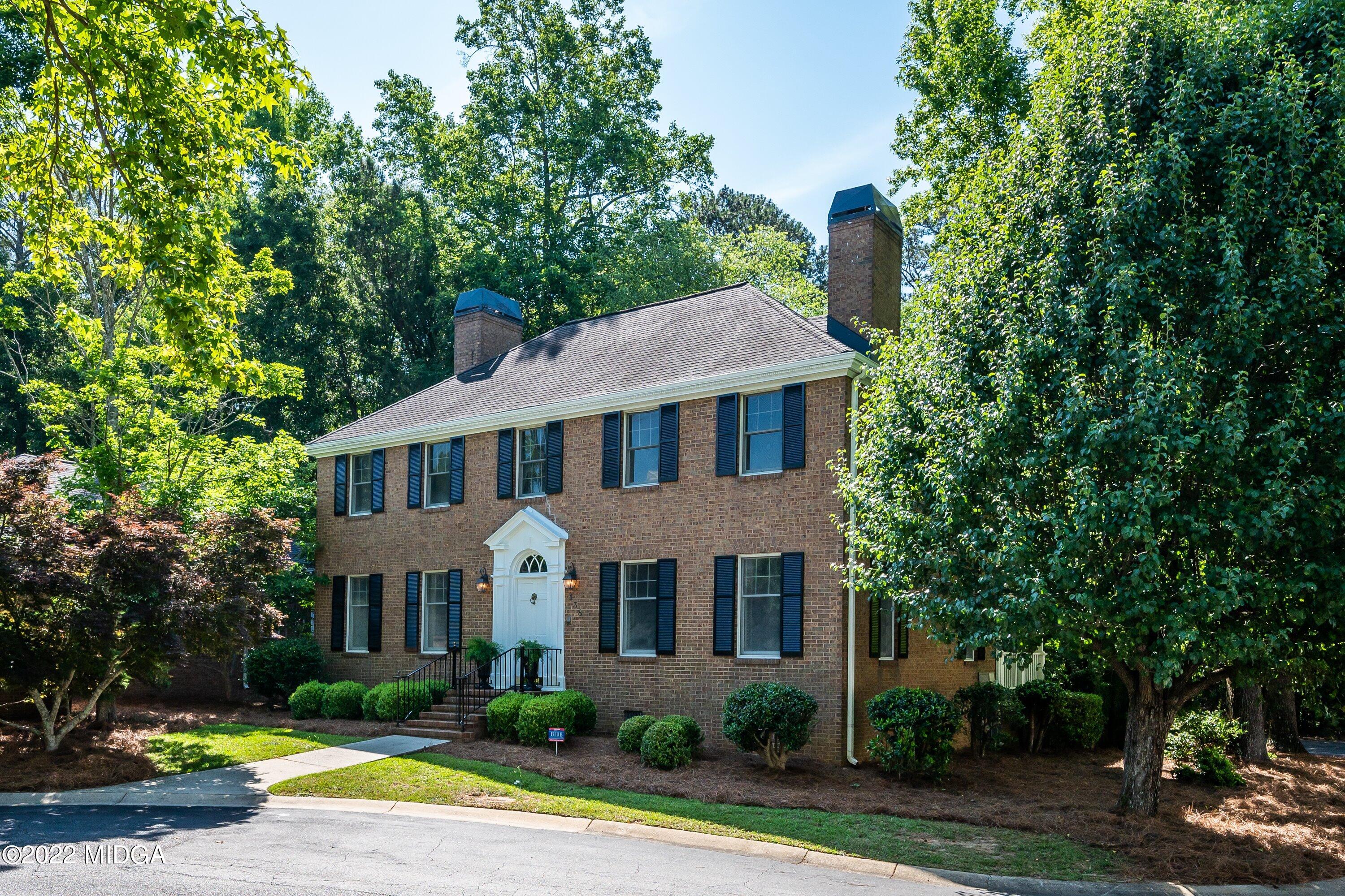 138 Covington Place, Unit 13 Macon, GA 31210 - Photo 21 of 23 a view of a white house with a big yard and large trees