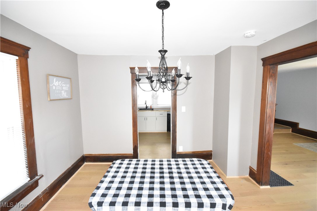 808 West Riddle Avenue Ravenna, OH 44266 - Photo 7 of 28 Dining room with sink, an inviting chandelier, and light hardwood / wood-style floors