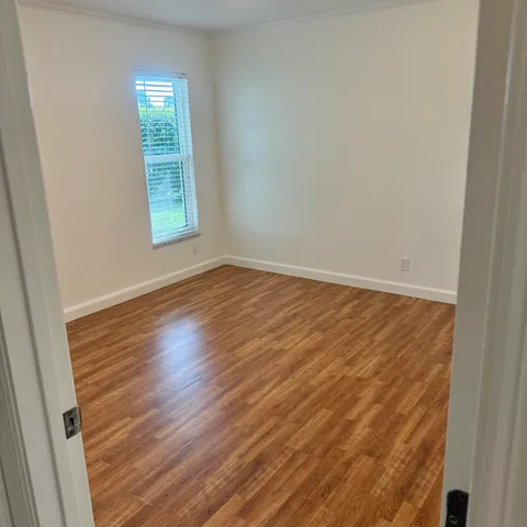 a view of an empty room with wooden floor