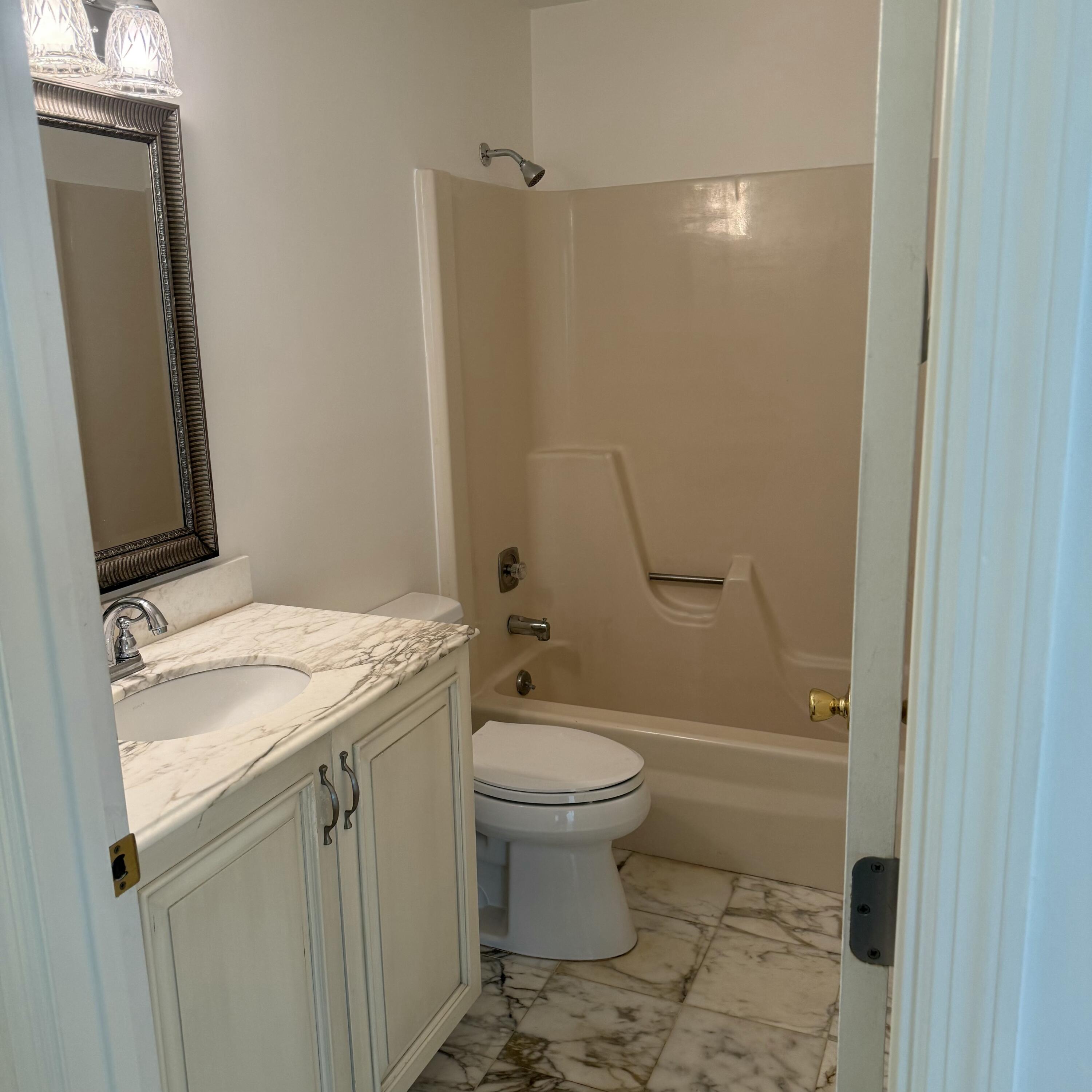 431 Jupiter Lakes Boulevard, Unit 2112A Jupiter, FL 33458 - Photo 16 of 19 a bathroom with a granite countertop sink toilet and shower
