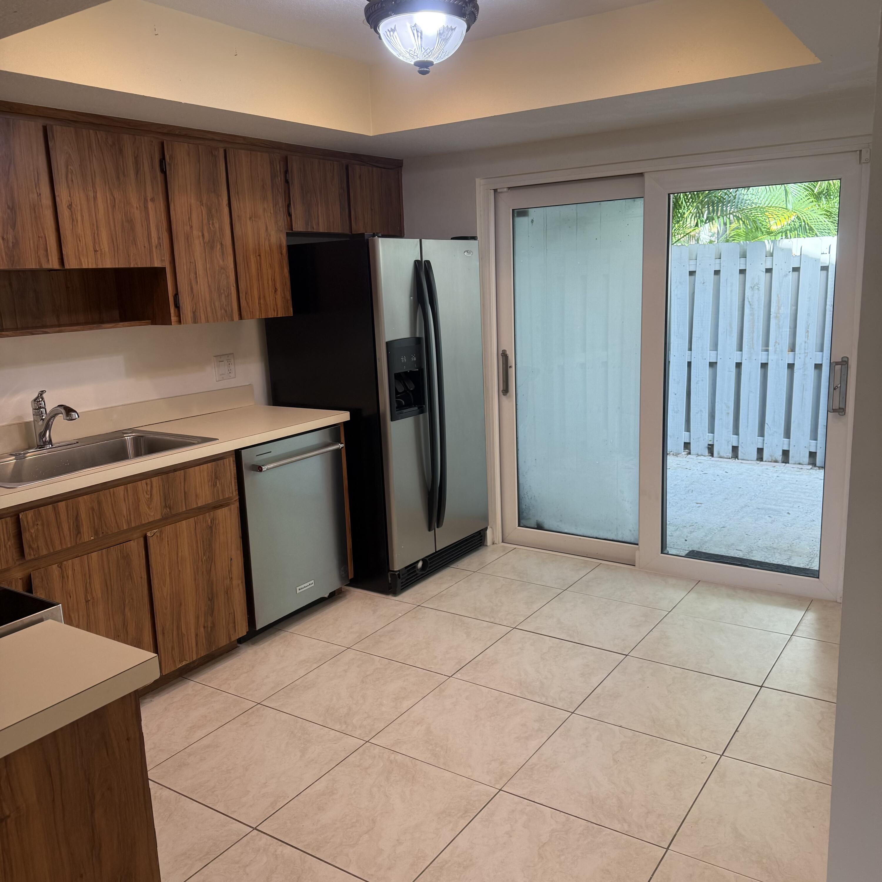 431 Jupiter Lakes Boulevard, Unit 2112A Jupiter, FL 33458 - Photo 5 of 19 a kitchen with stainless steel appliances granite countertop a refrigerator and a sink