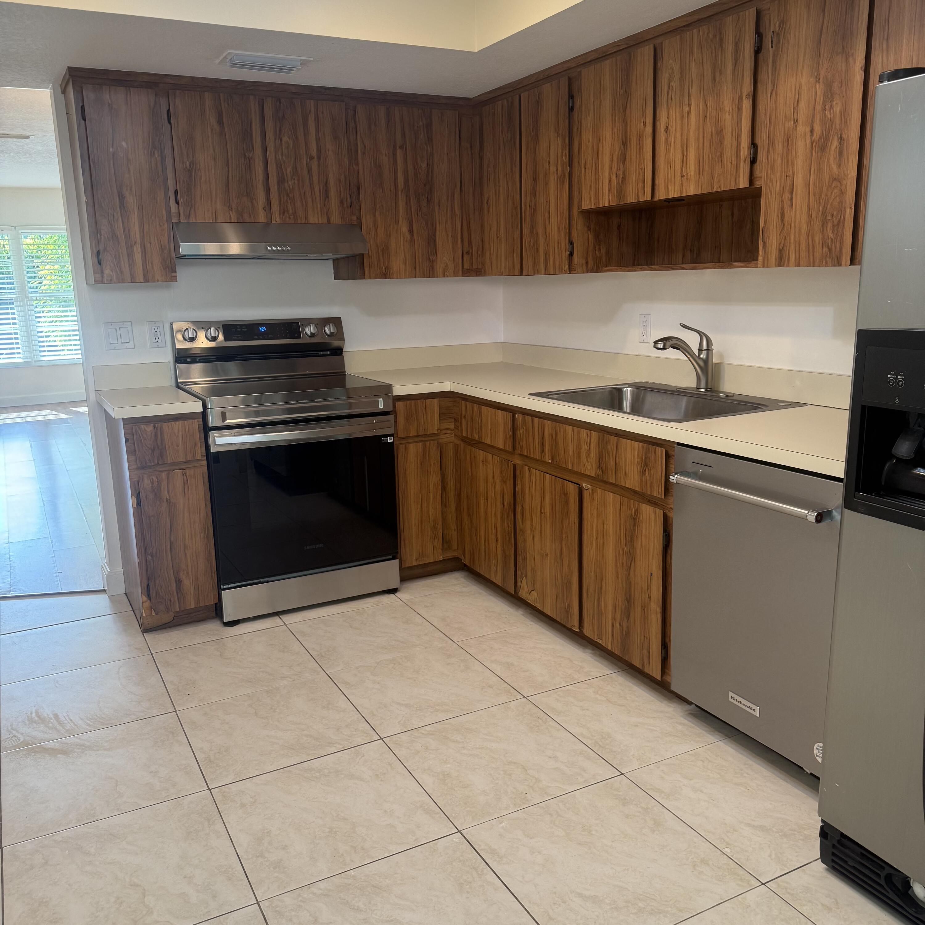 431 Jupiter Lakes Boulevard, Unit 2112A Jupiter, FL 33458 - Photo 6 of 19 a kitchen with a sink a stove and cabinets