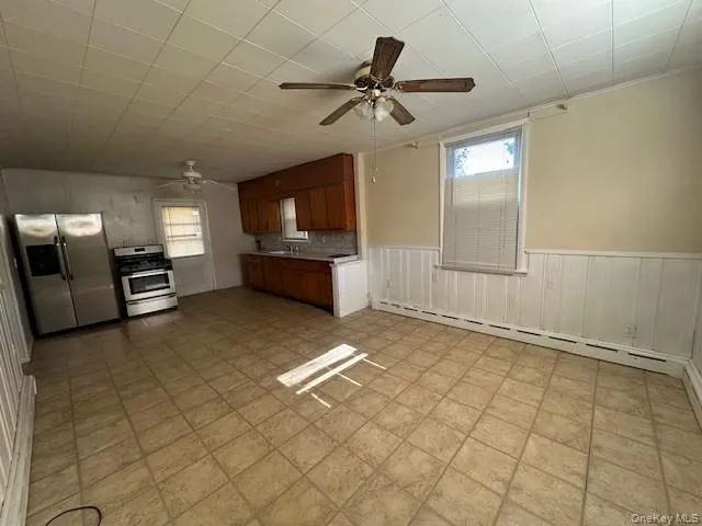 a view of a livingroom with a flat screen tv wooden floor and a ceiling fan