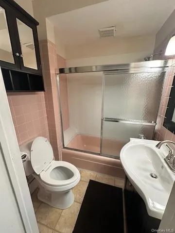 a bathroom with a sink a toilet a mirror and shower