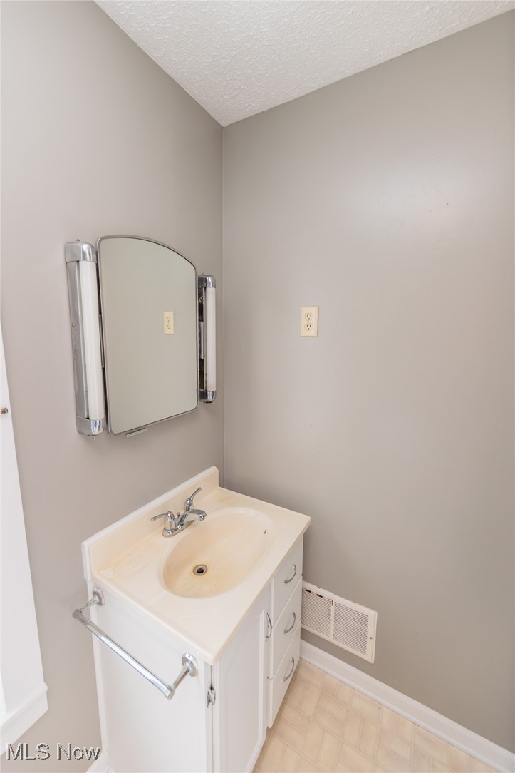 1866 Alpha Road Greenwich, OH 44837 - Photo 33 of 50 Bathroom with vanity, a textured ceiling, and tile patterned floors