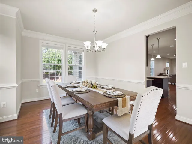 a dining room with furniture a chandelier and wooden floor