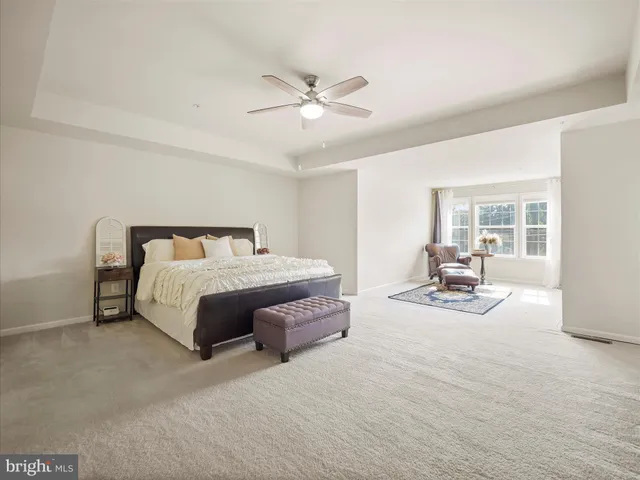 a spacious bedroom with a bed a table and large window