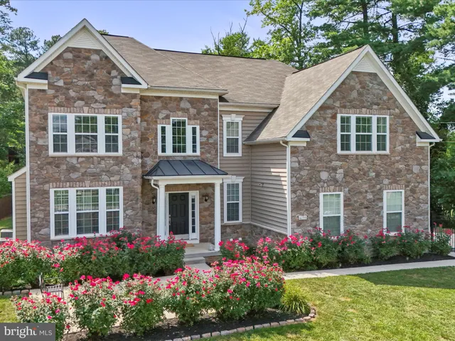 a front view of a house with a yard and potted plants