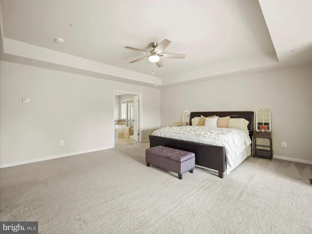 a spacious bedroom with a bed and a chandelier