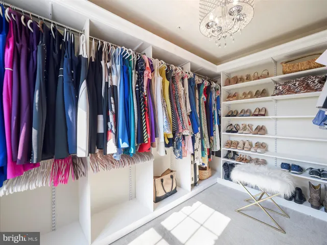 a view of walk in closet with clothes and shoes