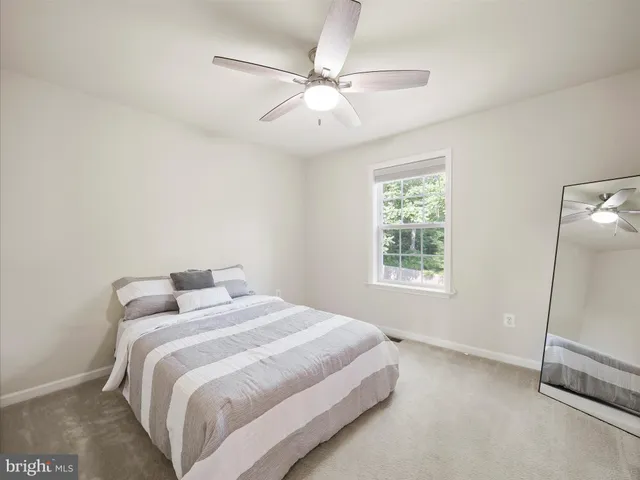 a bedroom with a large bed and a ceiling fan