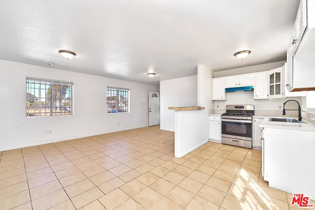a kitchen with granite countertop white cabinets and stainless steel appliances