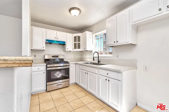 a kitchen with stainless steel appliances granite countertop a sink and a stove
