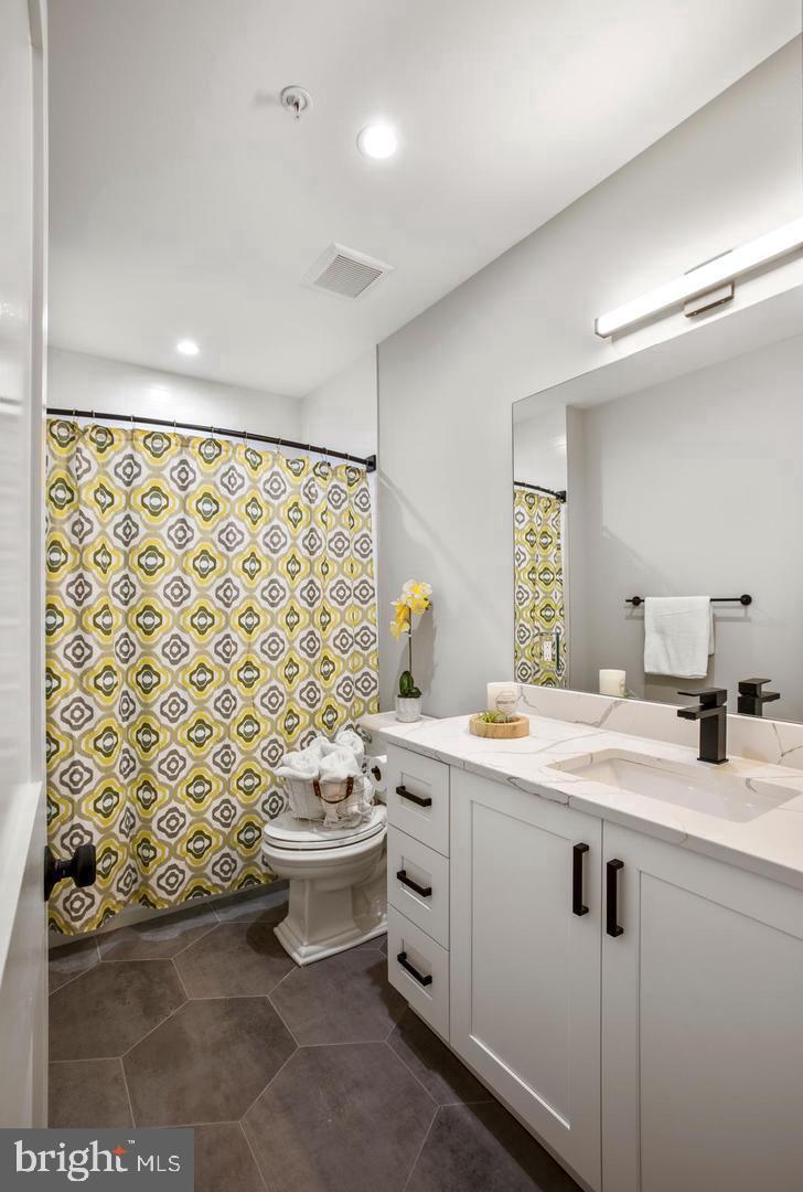 1420 Staples Street Northeast, Unit 2 Washington, DC 20002 - Photo 10 of 17 a bathroom with a double vanity sink toilet and shower
