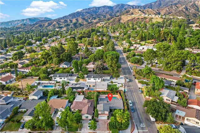 an aerial view of residential houses with outdoor space and trees