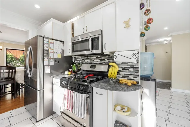 a kitchen with stainless steel appliances a stove a refrigerator sink and cabinets