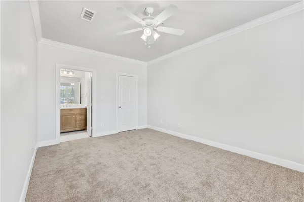 an empty room with chandelier fan and windows