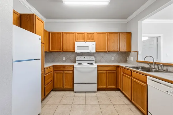 a kitchen with a refrigerator sink and cabinets