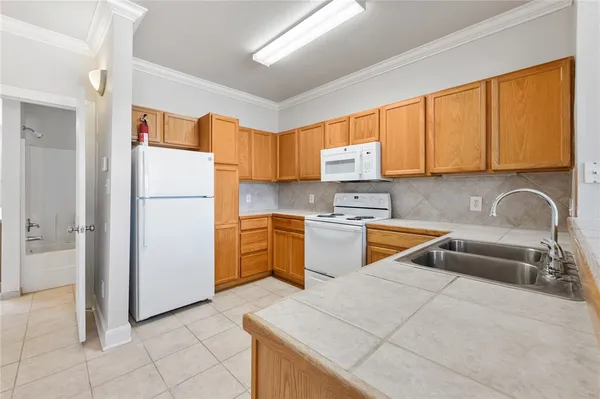 a kitchen with a sink a stove and a refrigerator