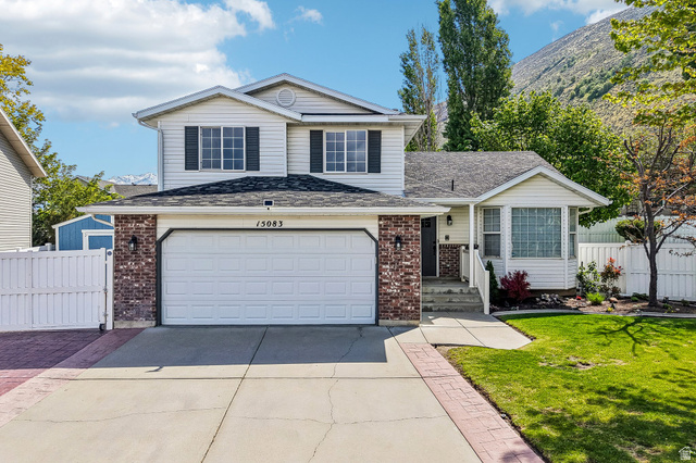 Traditional-style house featuring concrete driveway, brick siding, and a shingled roof