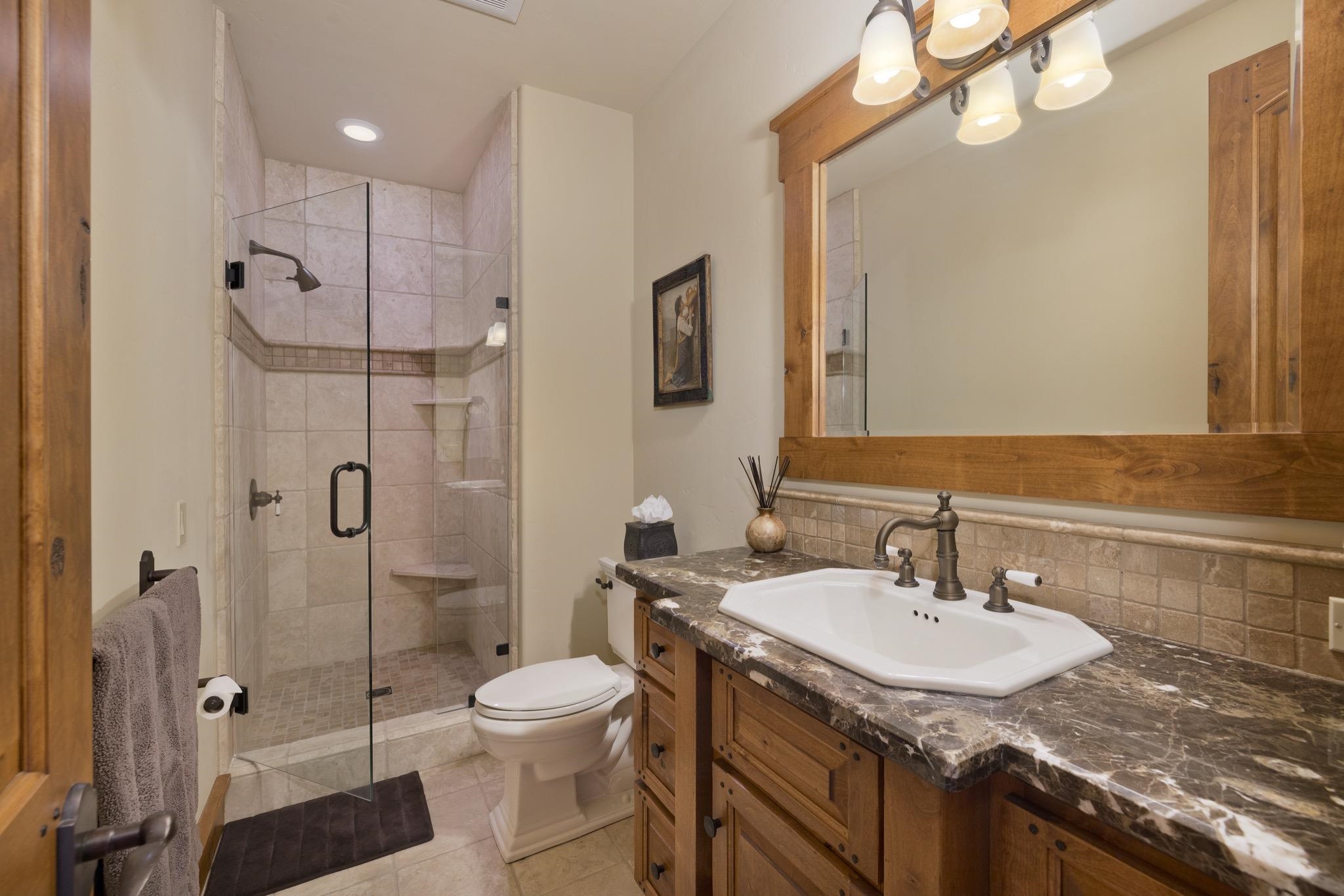 269 Juniper Road Mammoth Lakes, CA 93546 - Photo 45 of 56 a bathroom with a granite countertop sink a toilet and shower