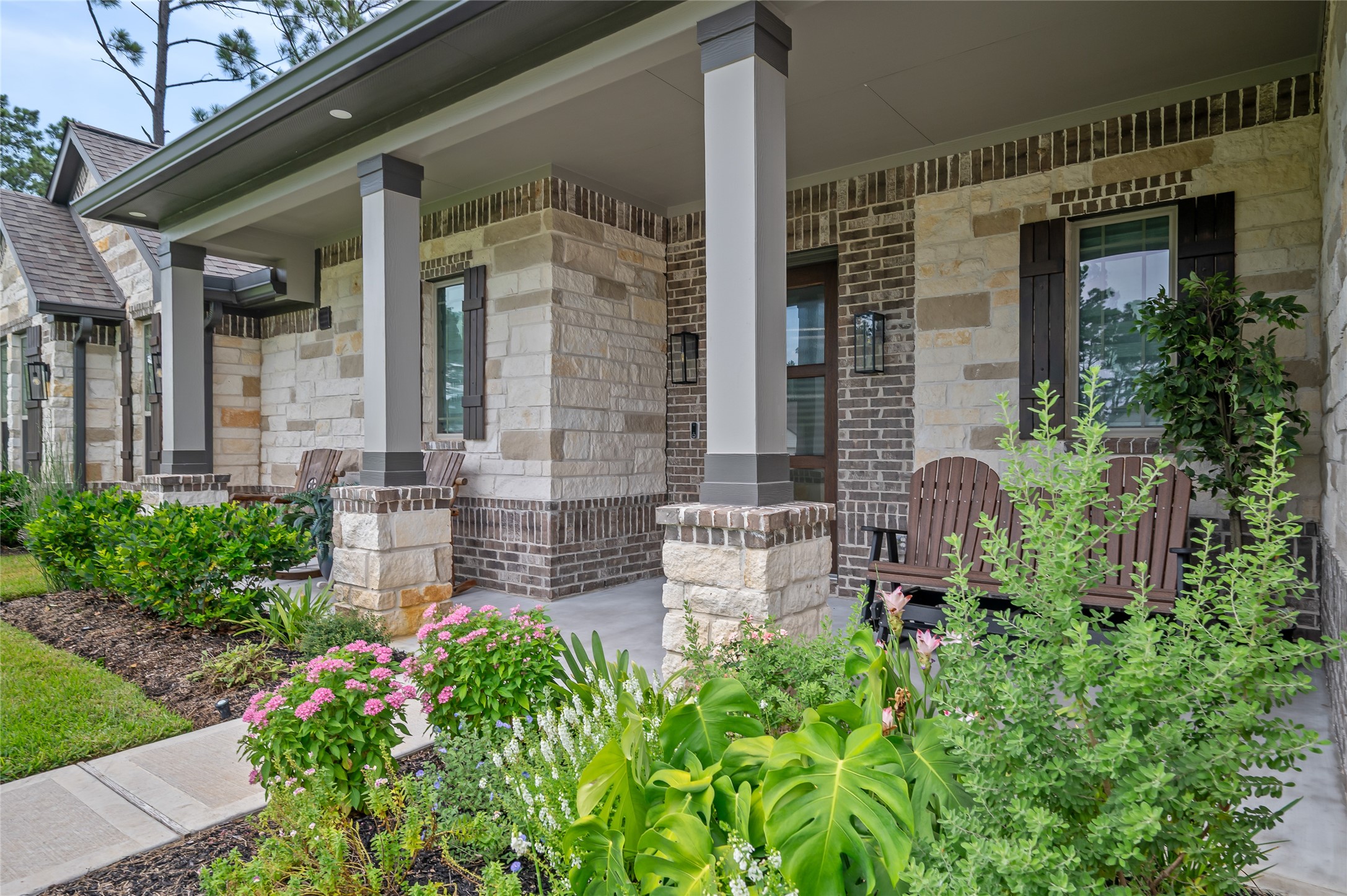 13419 Maverick Trail Road Conroe, TX 77303 - Photo 35 of 49 Oversized covered front porch with stone-and-brick accents and lush landscaping.