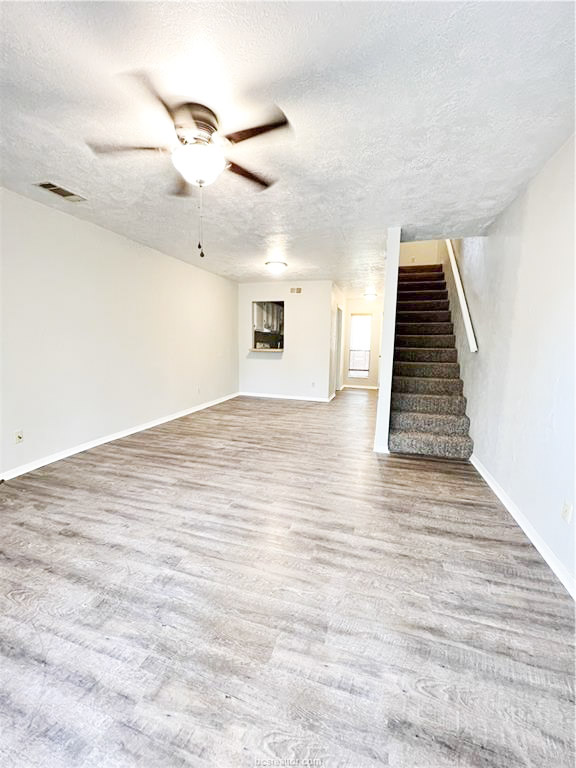 3802 College Main Street, Unit 6 Bryan, TX 77801 - Photo 4 of 12 an empty room with wooden floor ceiling fan and windows