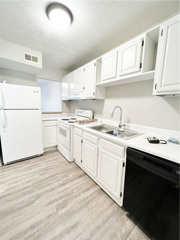 3802 College Main Street, Unit 6 Bryan, TX 77801 - Photo 8 of 12 a kitchen with a sink white cabinets and white appliances
