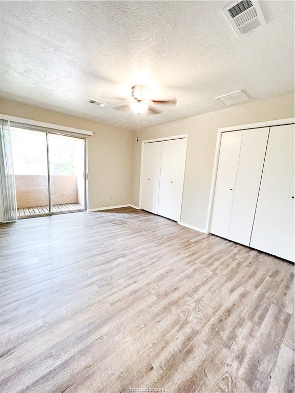 3802 College Main Street, Unit 6 Bryan, TX 77801 - Photo 9 of 12 an empty room with wooden floor and windows with curtains