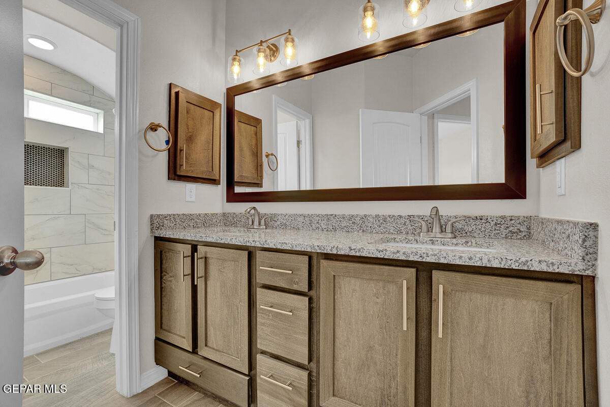 6924 Levee Circle Anthony, NM 88021 - Photo 27 of 36 a bathroom with a granite countertop sink and a mirror