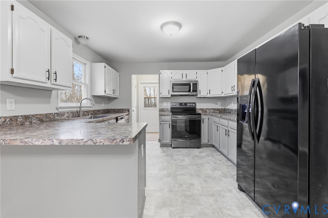 836 Walkerton Road Walkerton, VA 23177 - Photo 11 of 29 a kitchen with kitchen island granite countertop stainless steel appliances a sink a stove a refrigerator a counter top space and cabinets