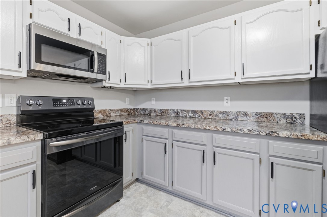 836 Walkerton Road Walkerton, VA 23177 - Photo 9 of 29 a kitchen with granite countertop white cabinets and a stove top oven