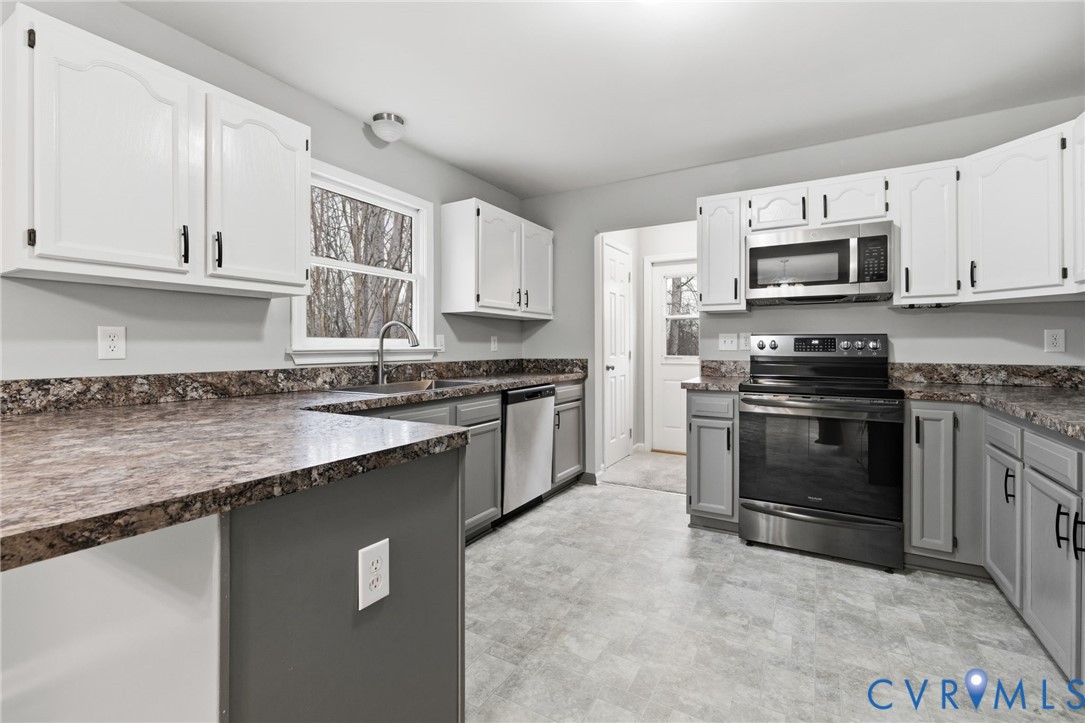 836 Walkerton Road Walkerton, VA 23177 - Photo 10 of 29 a kitchen with granite countertop a sink a stove and cabinets