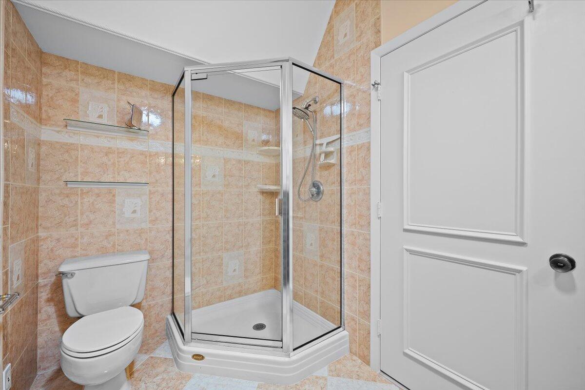 352 River Edge Road Jupiter, FL 33477 - Photo 28 of 56 a bathroom with a shower a toilet and a glass door