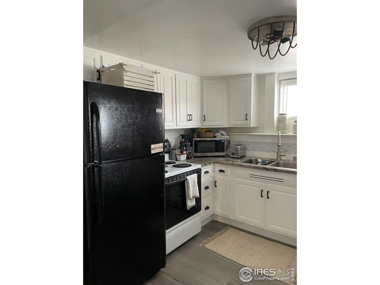 125 West Trilby Road Fort Collins, CO 80525 - Photo 17 of 26 a kitchen with a refrigerator and cabinets