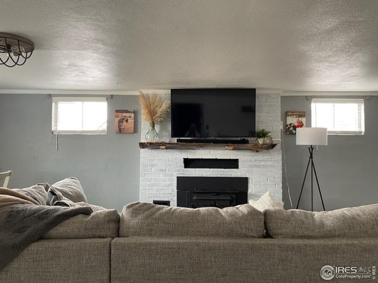 125 West Trilby Road Fort Collins, CO 80525 - Photo 22 of 26 a living room with furniture a fireplace and a flat screen tv