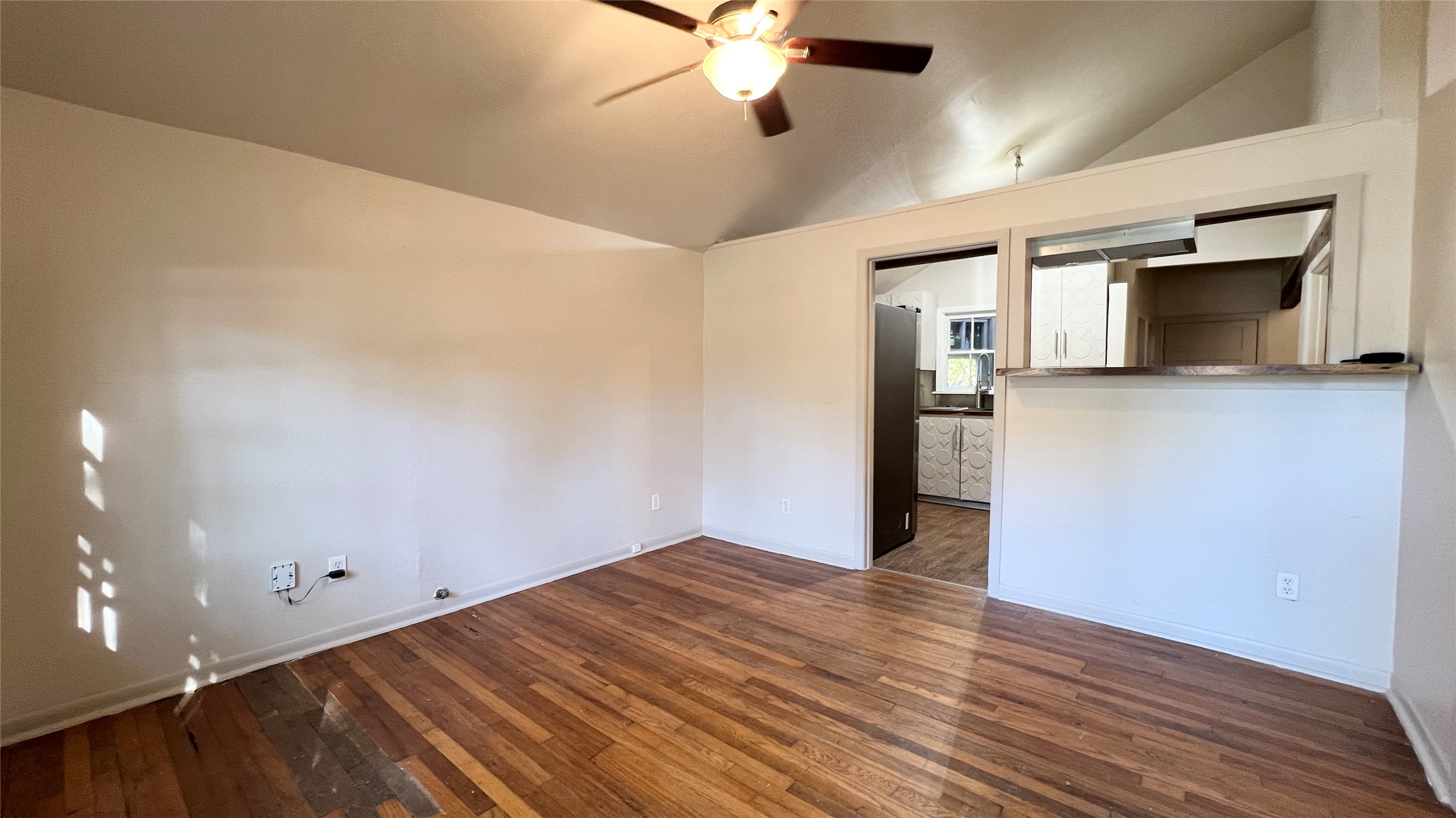 2104 West 7th Street Austin, TX 78703 - Photo 2 of 11 Spare room with dark wood-type flooring, vaulted ceiling, and ceiling fan