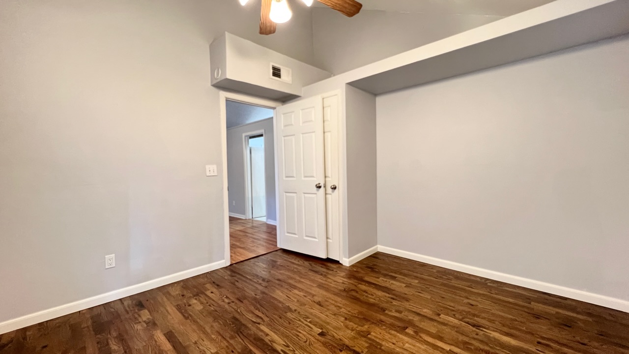 2104 West 7th Street Austin, TX 78703 - Photo 5 of 11 Empty room featuring a ceiling fan, dark wood-style floors, and lofted ceiling