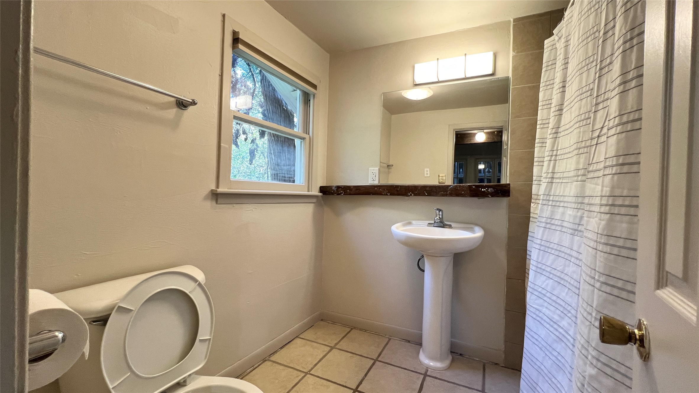 2104 West 7th Street Austin, TX 78703 - Photo 10 of 11 Bathroom featuring curtained shower and light tile patterned floors