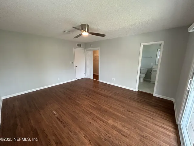 a backyard of a house with plants and palm trees